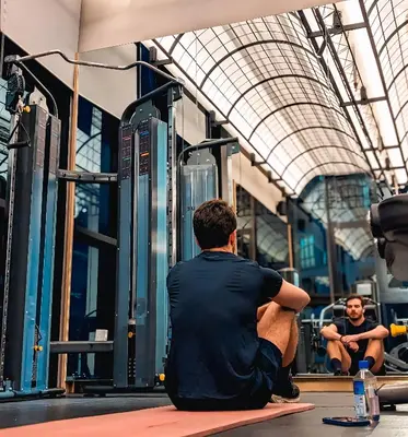 a man sitting on the floor in a gym at 183 Ampang KLCC by Widebed in Kuala Lumpur