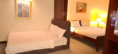 a hotel room with two beds and a chair at B Service apartment times Square kl in Kuala Lumpur