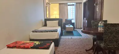 a room with two beds and a table and a desk at B Service apartment times Square kl in Kuala Lumpur