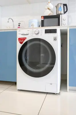 a white washing machine sitting in a kitchen at Continew Residensi City Comfort Stay Cozy 1BR 1BA in Kuala Lumpur