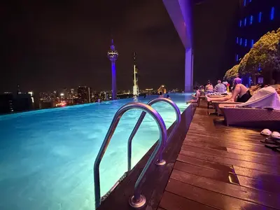a swimming pool with a view of the city at night at Platinum Klcc by PureStay in Kuala Lumpur