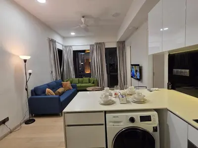 a kitchen and living room with a blue couch at KL Star Residance KLCC by Nexus 111 in Kuala Lumpur