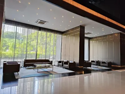 a lobby with chairs and tables and large windows at Opus Residences KL by PILLOWTALKS in Kuala Lumpur