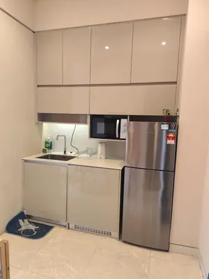 a kitchen with a stainless steel refrigerator and cabinets at One Bedroom Apartment Lucentia Residence in Kuala Lumpur