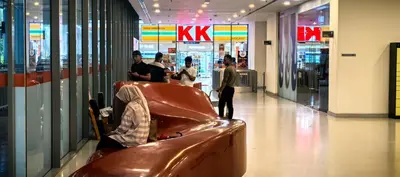 a man sitting on a bench in a shopping mall at summer suite, KLCC in Kuala Lumpur