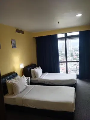 two beds in a hotel room with a window at Krish Apartment At Times Square in Kuala Lumpur