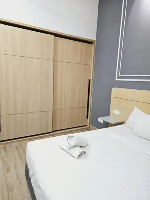 a bedroom with a large white bed with a wooden headboard at Grand infinitum suites KLCC by PN in Kuala Lumpur