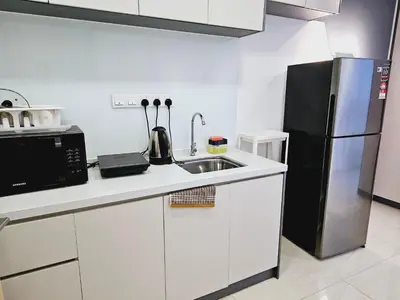 a kitchen with a sink and a black refrigerator at Grand infinitum suites KLCC by PN in Kuala Lumpur