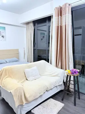 a bedroom with a large bed and a table at Sea Homestay in Kuala Lumpur
