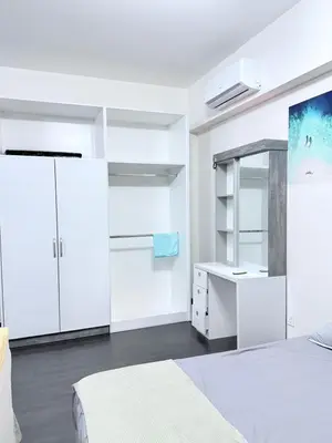 a white bedroom with white cabinets and a bed at Sea Homestay in Kuala Lumpur