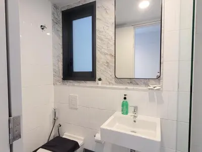a white bathroom with a sink and a mirror at Isola KLCC Residence in Kuala Lumpur