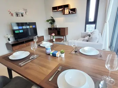 a living room with a wooden table with plates and wine glasses at Isola KLCC Residence in Kuala Lumpur