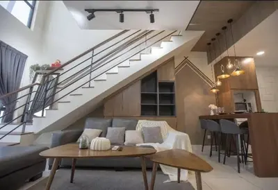 a living room with a couch and a staircase at BMC Arte Mont Kiara in Kuala Lumpur