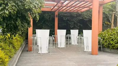 a row of white tables and chairs on a patio at MH Rest House at Majestic Residence in Kuala Lumpur