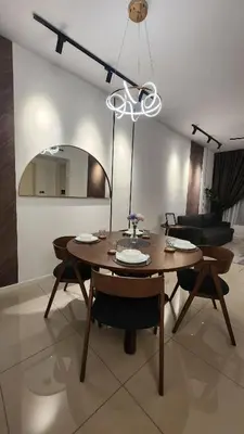 a dining room with a table and chairs and a chandelier at KL Nice Condo in Kuala Lumpur