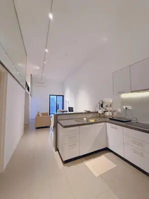 a large kitchen with white cabinets and a couch at EST Establishment Bangsar in Kuala Lumpur
