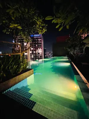 a swimming pool lit up at night at Majestic Residence Klcc by Apple in Kuala Lumpur