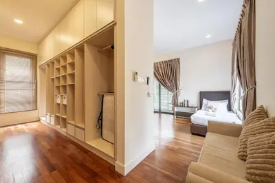 a bedroom with a bed and a living room with a couch at The Noble Bungalow, 18pax 5R4B near Datuk Keramat, KL Pavilion in Kuala Lumpur