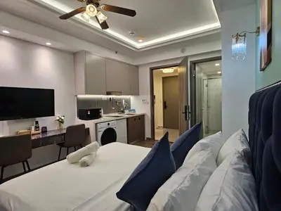 a living room with a white couch and a kitchen at Bukit Bintang Agile 400m to TRX DualKey 2-7pax in Kuala Lumpur