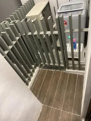 a staircase with a fence next to a refrigerator at INFINITUM Stay at klcc in Kuala Lumpur