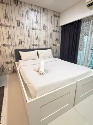 a white bed with a teddy bear sitting on it at CozyNest KLCC at Mercu Summer Suites in Kuala Lumpur
