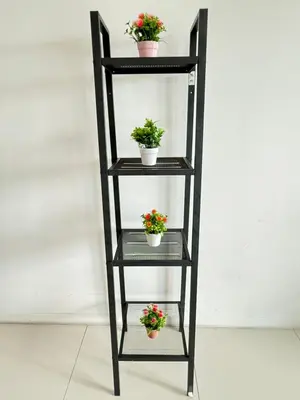 a black shelf with three potted plants on it at CozyNest KLCC at Mercu Summer Suites in Kuala Lumpur