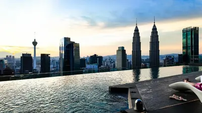 a infinity pool on the top of a skyscraper with the petronas towers at Imperial Residence KLCC - MJ Home in Kuala Lumpur