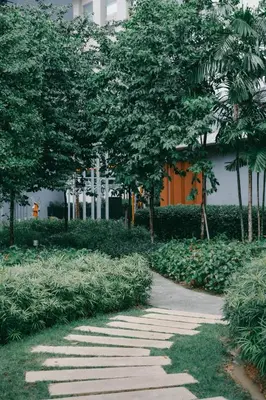 a walkway in a park with trees and a building at Cozy Minimalist Studio KL, Agile Residence Bukit Bintang in Kuala Lumpur