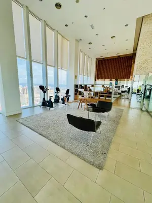 a lobby with chairs and tables in a building with windows at Peace Pavilion At Platinum in Kuala Lumpur