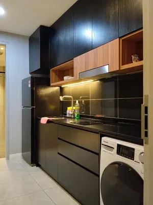 a kitchen with black cabinets and a white dishwasher at Unitopia near KLCC pavillion in Kuala Lumpur