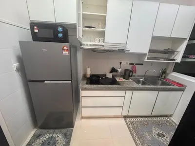 a small kitchen with a refrigerator and a sink at Desa green apartment in Kuala Lumpur