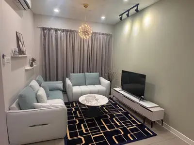 a living room with a couch and a tv at Desa green apartment in Kuala Lumpur
