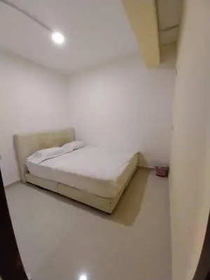 a bedroom with a bed in a white room at SHAMA HoTEL in Kuala Lumpur