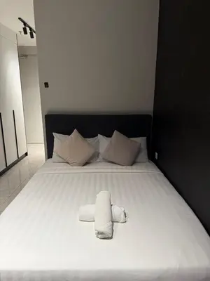 a bed with two towels sitting on top of it at Astra At Axon Bukit Bintang KL in Kuala Lumpur