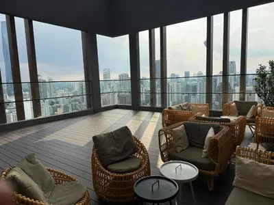 a balcony with chairs and tables on the top of a building at Astra At Axon Bukit Bintang KL in Kuala Lumpur