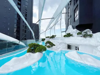 a swimming pool with icebergs and plants in a city at Arte Mont Kiara by whitedoorz Apartment in Kuala Lumpur