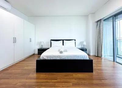 a white bedroom with a bed and a large window at Summer Suites KLCC Vibes in Kuala Lumpur