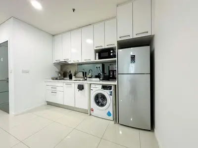 a kitchen with a refrigerator and a washing machine at Summer Suites KLCC Vibes in Kuala Lumpur
