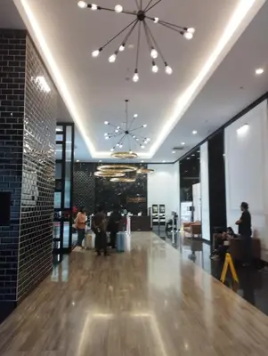 a lobby with people sitting in a building with a chandelier at Chambers residence klcc by Gajilion in Kuala Lumpur