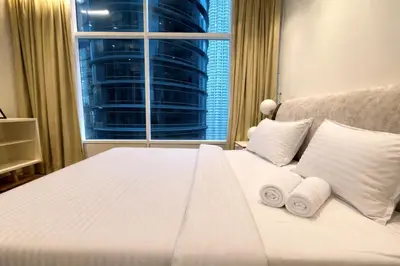 a bedroom with a white bed with towels on it at Sky Suites KLCC By Sky Management in Kuala Lumpur