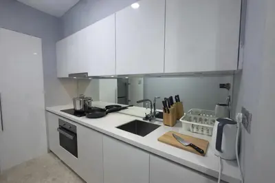 a white kitchen with a sink and a stove at Sky Suites KLCC By Sky Management in Kuala Lumpur