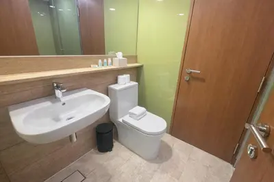 a bathroom with a sink and a toilet and a mirror at Sky Suites KLCC By Sky Management in Kuala Lumpur