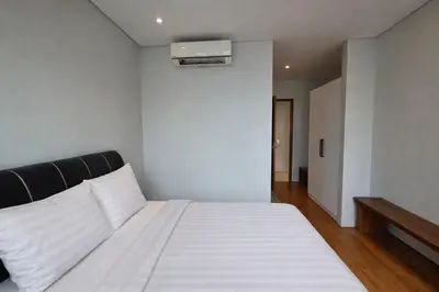 a bedroom with a white bed with a black headboard at Sky Suites KLCC By Sky Management in Kuala Lumpur