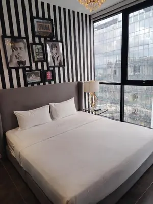 a large white bed in a room with black and white stripes at Scarletz Suites KLCC Twin Tower by Skyview in Kuala Lumpur