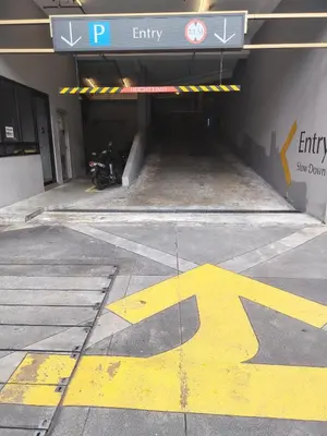 a parking garage with a yellow arrow painted on the ground at Scarletz Suites KLCC Twin Tower by Skyview in Kuala Lumpur