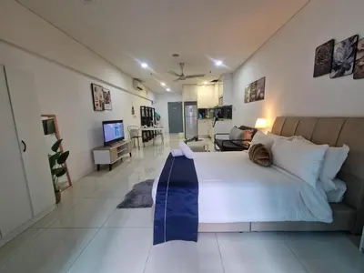 a bedroom with a large bed and a living room at Summer suites klcc 5 min walk by AA Global in Kuala Lumpur