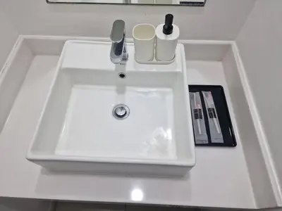 a white sink in a white bathroom with a book at Summer suites klcc 5 min walk by AA Global in Kuala Lumpur