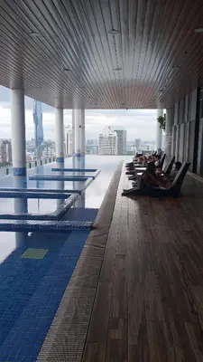 a pool with people laying on lounge chairs in a building at The Colony Infinitum KLCC Suits By Sabu in Kuala Lumpur