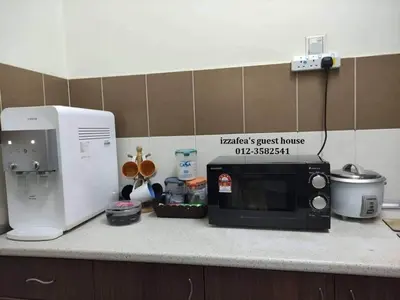 a kitchen counter with a microwave and a coffee maker at Izzafea in Ampang