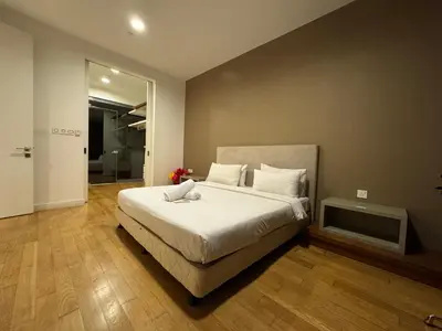 a bedroom with a large bed with white sheets at White stone suites in Kuala Lumpur